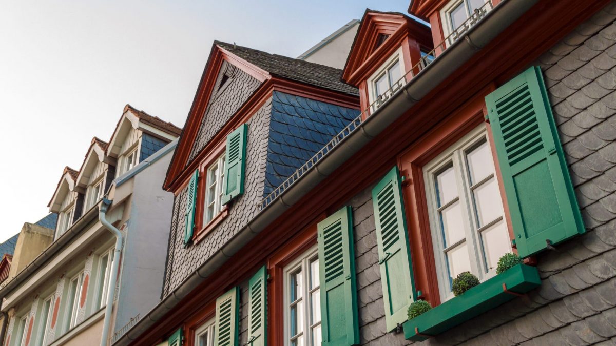 windows with green wooden shutters in old house. Outdoors exterior