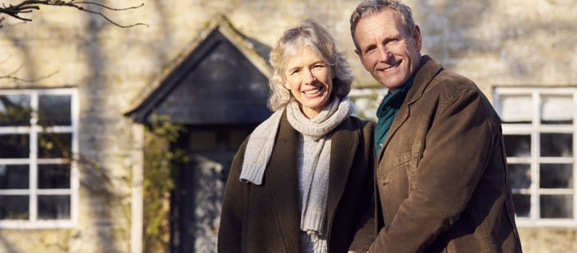 Portrait Of Retired Senior Couple Standing Outside Home Together