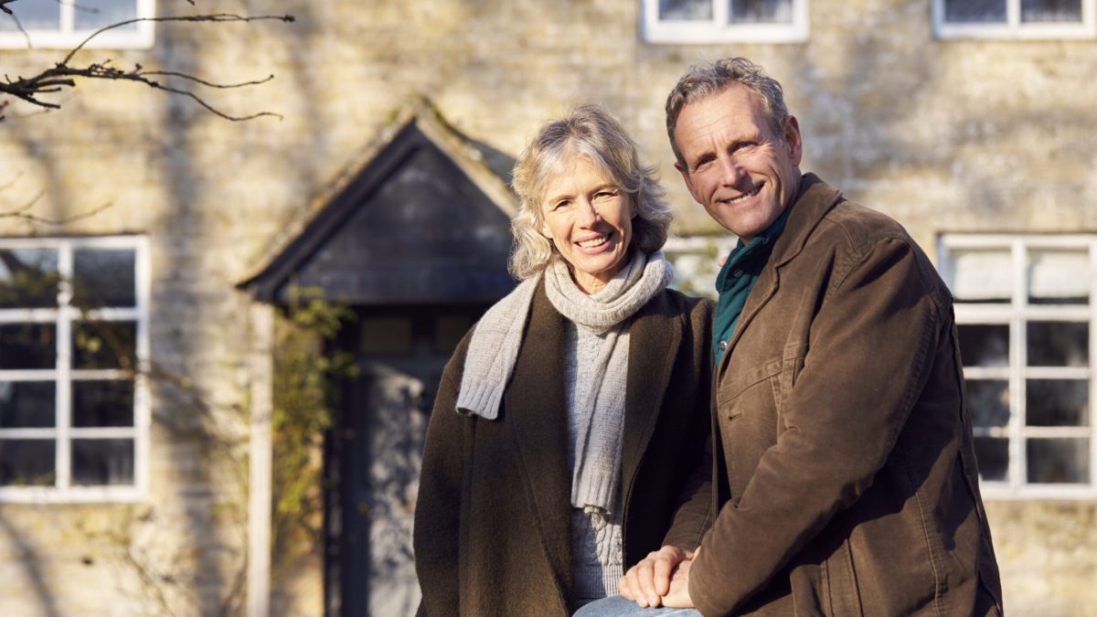 Portrait Of Retired Senior Couple Standing Outside Home Together